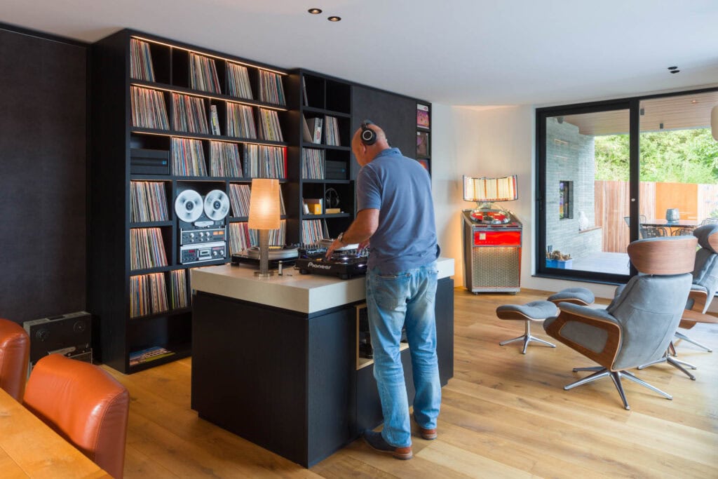 Moderne woonkamer met DJ apparatuur en vinylplaten.