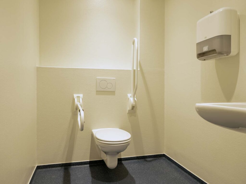 Toegankelijk toilet met hulpmiddelen en beugels voor mindervaliden.