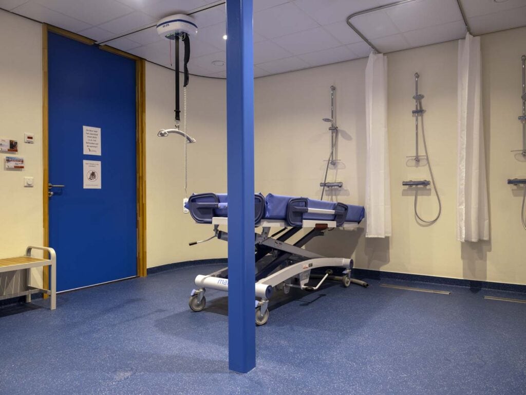 Ziekenhuis operatiekamer met medische apparatuur en bed, klaar voor chirurgische ingrepen.