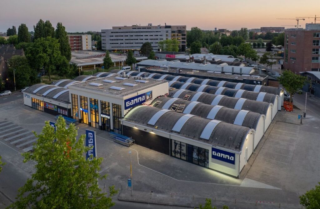 Bedrijfspand met unieke, gebogen dakstructuur en moderne gevel, gebouwd door JCVANKESSEL BOUW.
