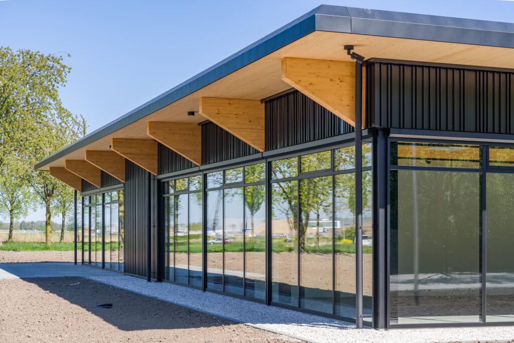 Modern bedrijfsgebouw met houten dak en glazen gevels voor zakelijke doeleinden.