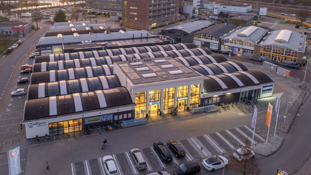 JCVANKESSEL BOUW - Modern bedrijfsgebouw met grote glaspartijen en parkeerplaatsen voor klanten.