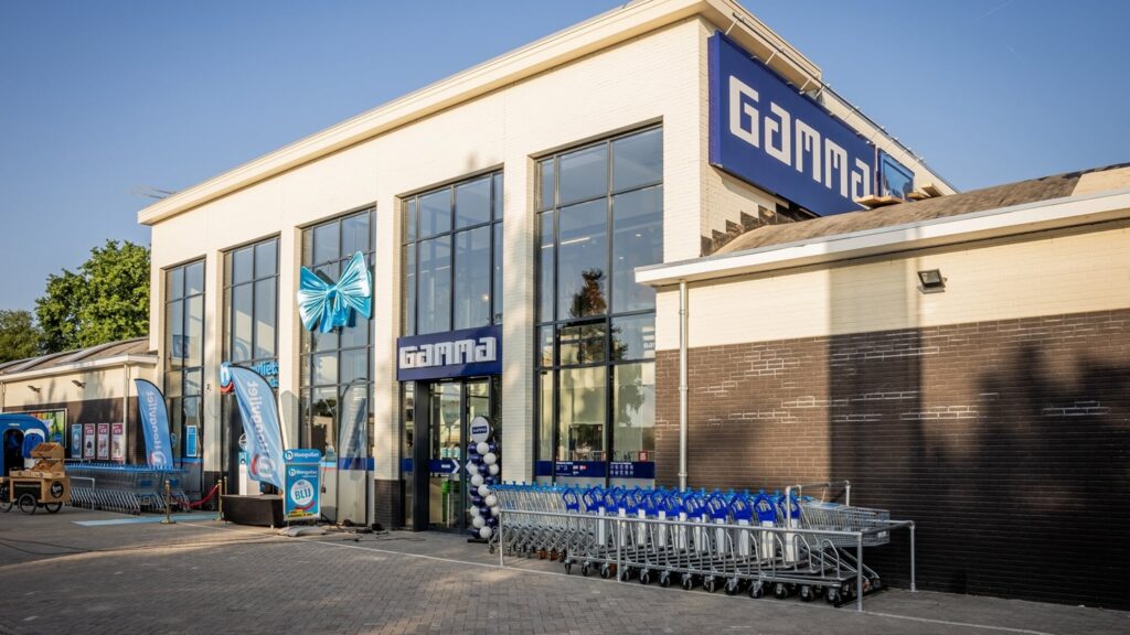 Modern bouwcentrum Gama met grote ramen en winkelwagentjes voor bouwmaterialen.