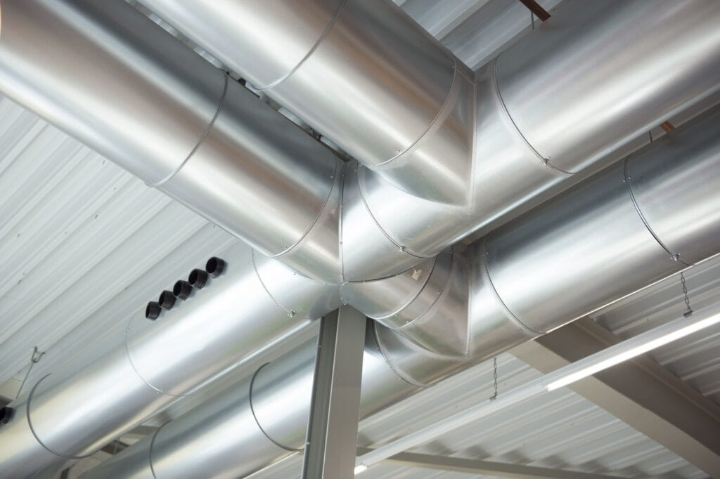 Industriële luchtbehandelingsbuizen en ventilatiesysteem in bedrijfsgebouw.