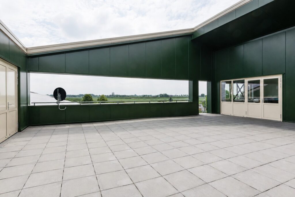 Ruim dakterras met groene gevel en uitzicht op landschap.
