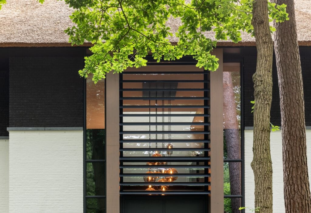 Houten gevel met moderne open haard, omringd door groene bomen, voor een stijlvolle en gezellige bui.