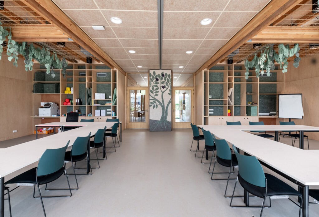 Moderne vergaderruimte met houten details en groene planten.