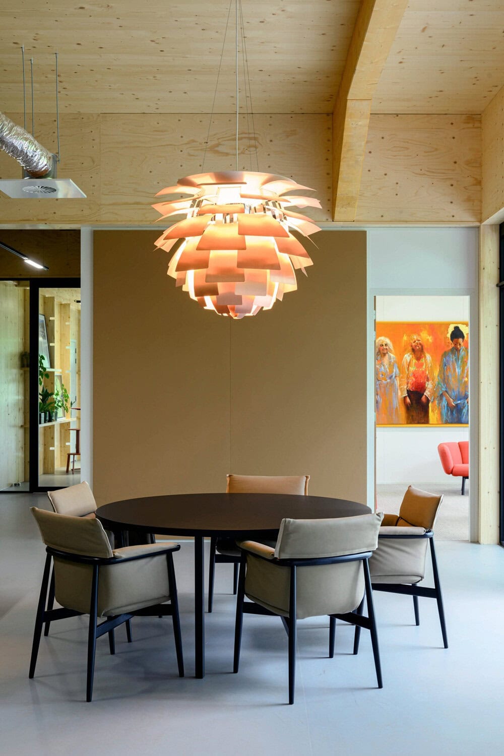 Moderne eetkamer met ronde tafel en opvallende hanglamp.