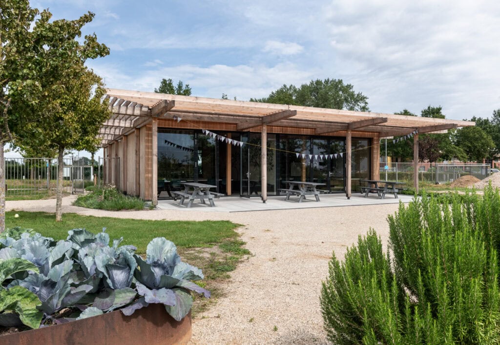 Moderne houten bouw met grote glazen ramen en terras.