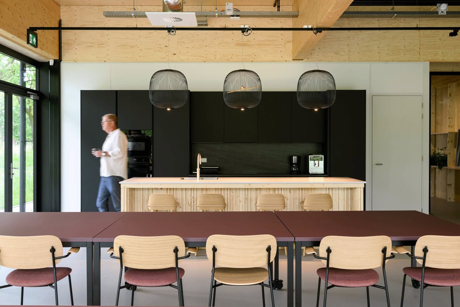 Moderne keuken en eetruimte met houten details en grote ramen.
