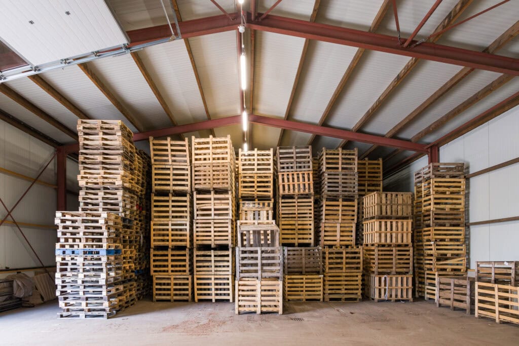 Opslagruimte met stapels houten pallets voor bouwprojecten.