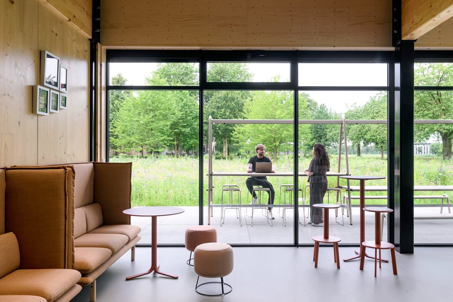 Moderne interieur met grote ramen en uitzicht op groene tuin.