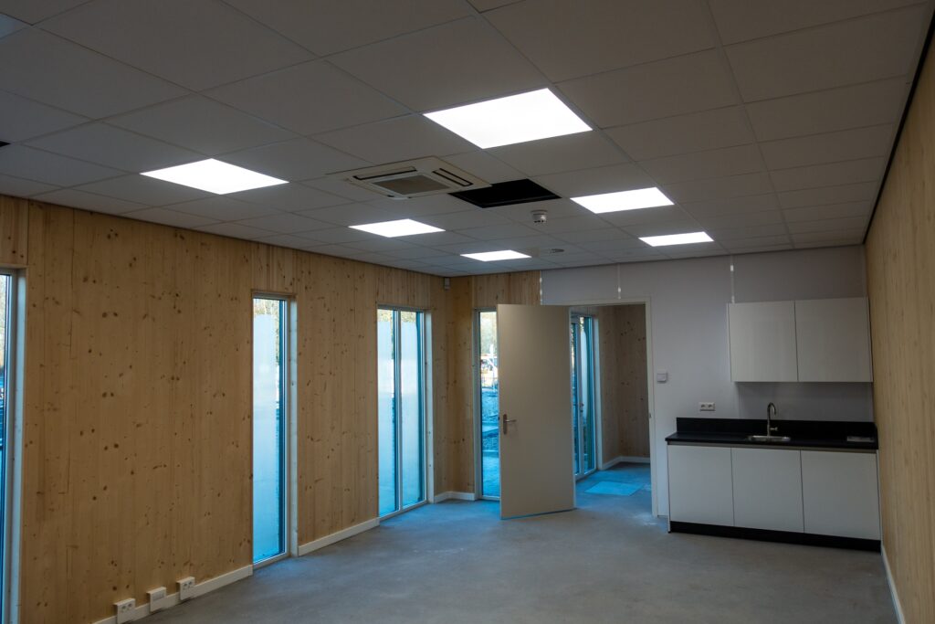 Moderne kantoorruimte met grote ramen en keuken in SynergyPark bedrijventerrein.