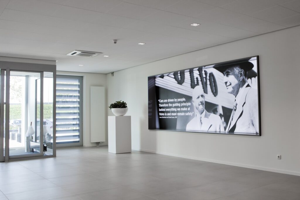 Moderne lobby met grote digitale schermen en natuurlijke lichtinval.