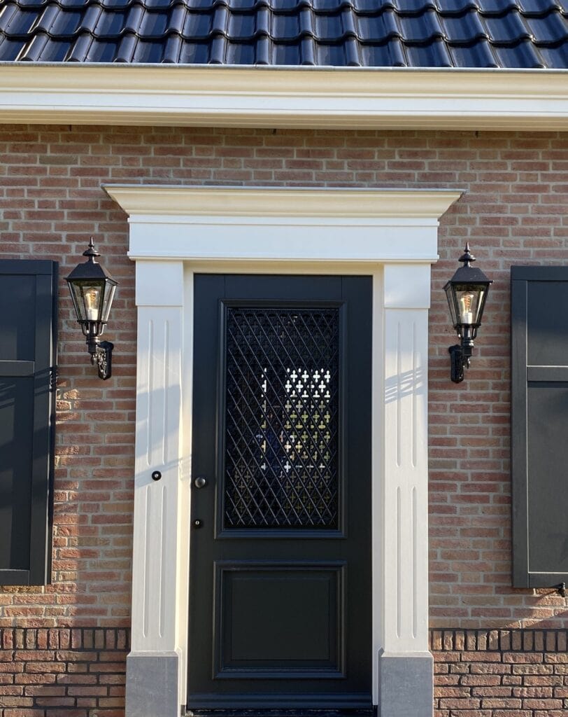 Voordeur van een notariswoning met bijgebouw en buitenverlichting.