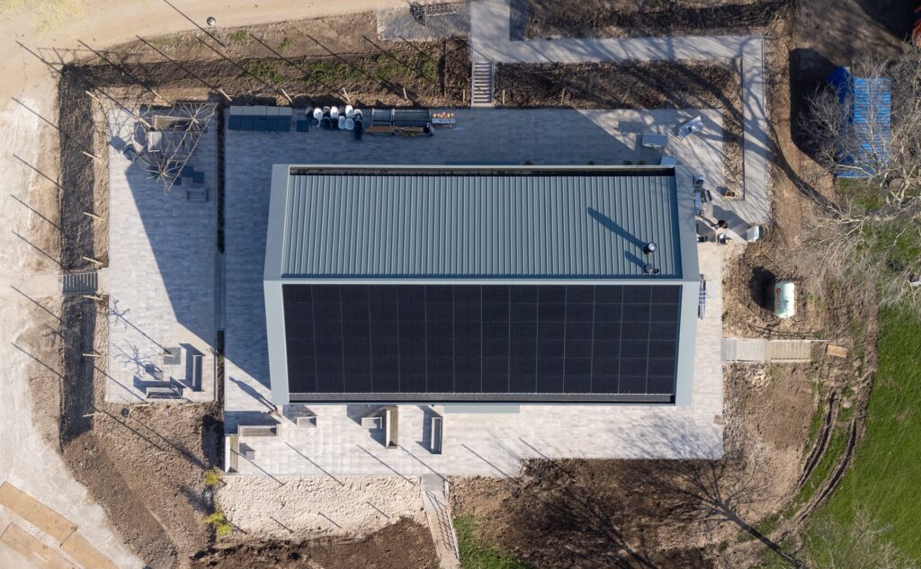 Modern gebouw met zonnepanelen en groene omgeving.