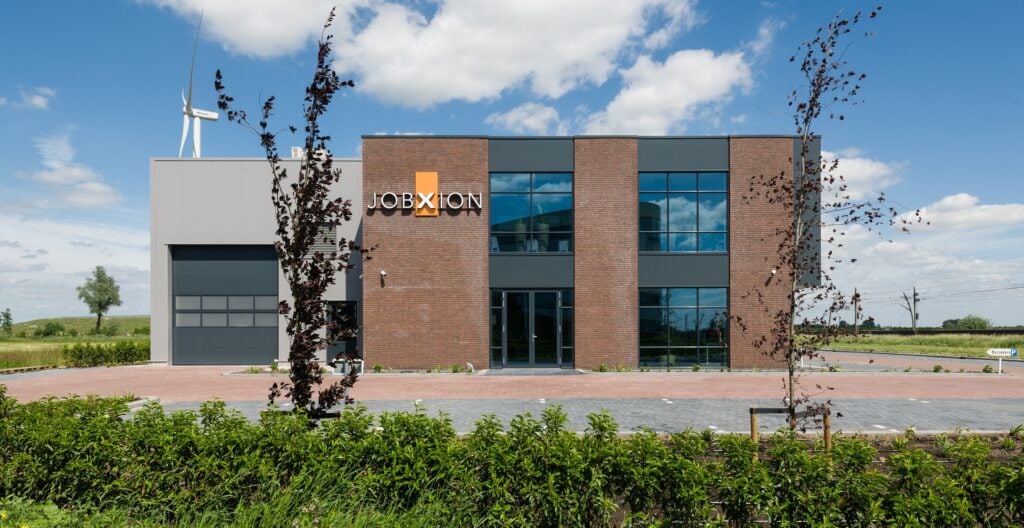 Modern bedrijfsgebouw van JCVANKESSEL BOUW met grote ramen en logo.