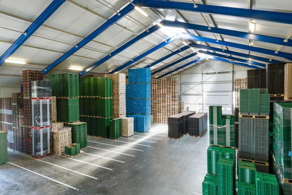 Binnenopslag van kunststof kratten in een magazijn van JCVANKESSEL Bouw.