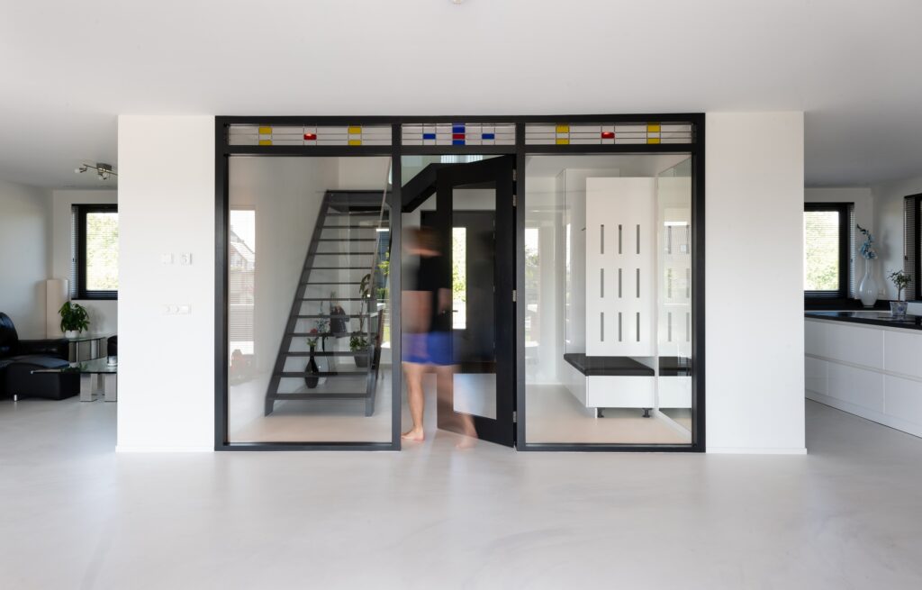 Moderne glazen schuifdeur met zwarte frame in huis.
