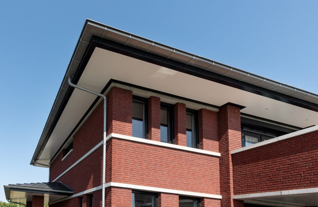 Moderne villa Noordijk met rode bakstenen en grote ramen.