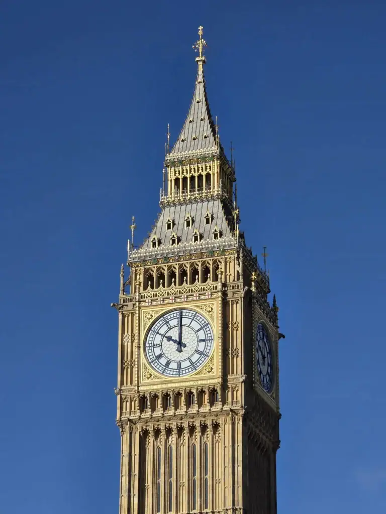 Iconisch beeld van Big Ben met blauwe lucht op de achtergrond.