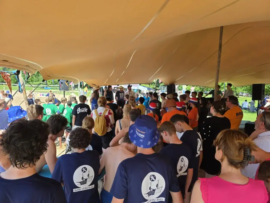 Grote groep mensen onder een tent tijdens een bouwgerelateerd evenement.